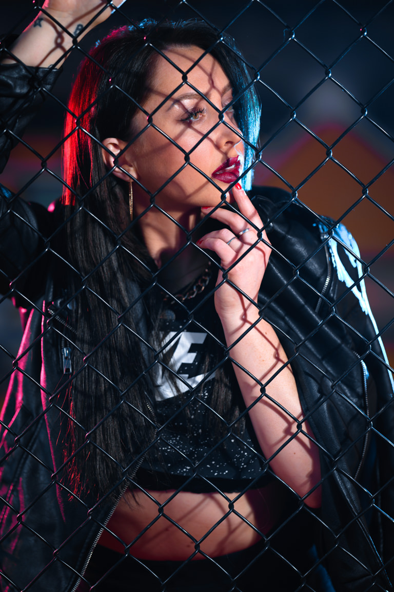 model posing behind fence with graffiti
